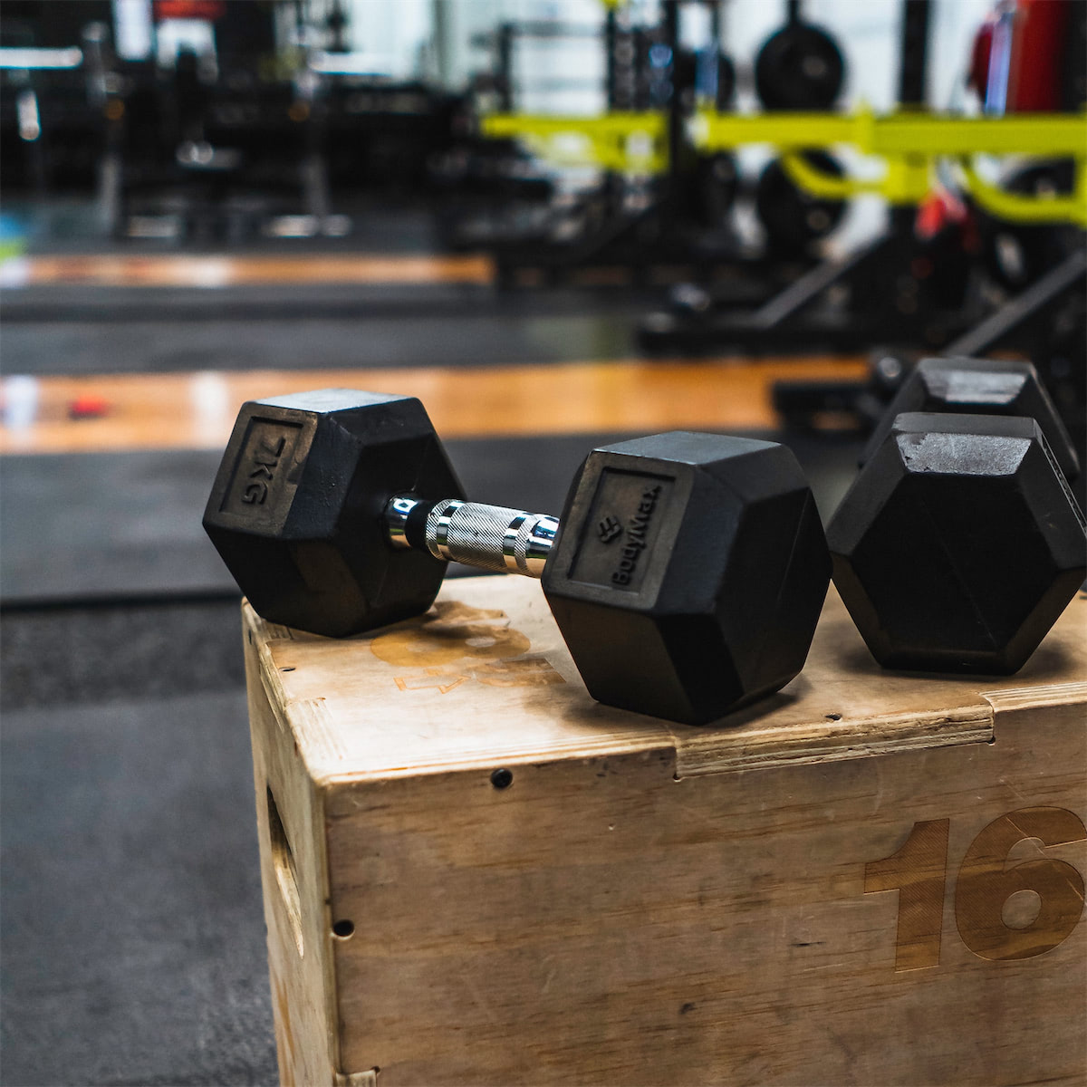 Two dumbbells sitting on a plyo box.
