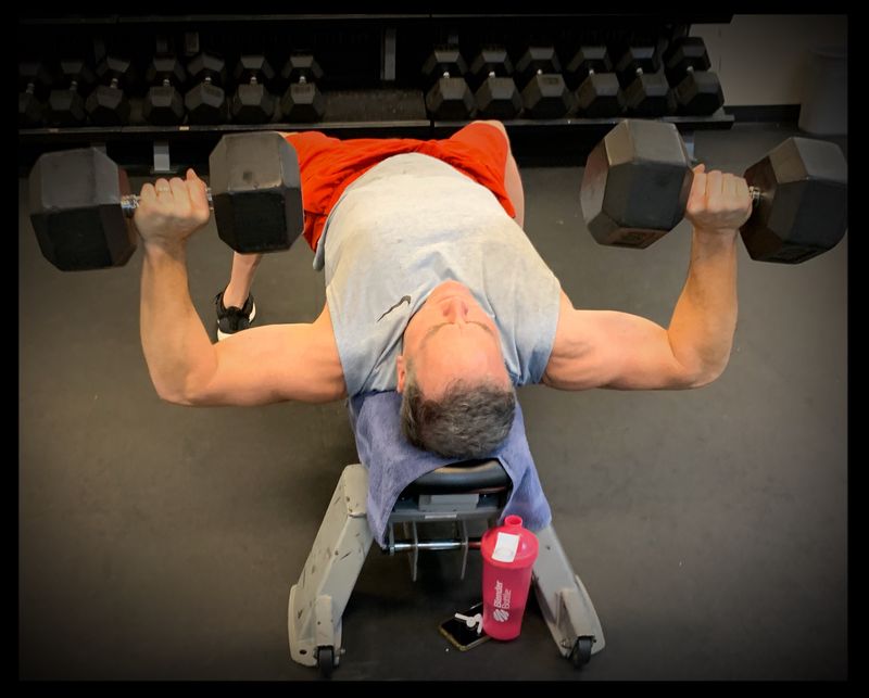 A member lifting dumbbells in the weight room.
