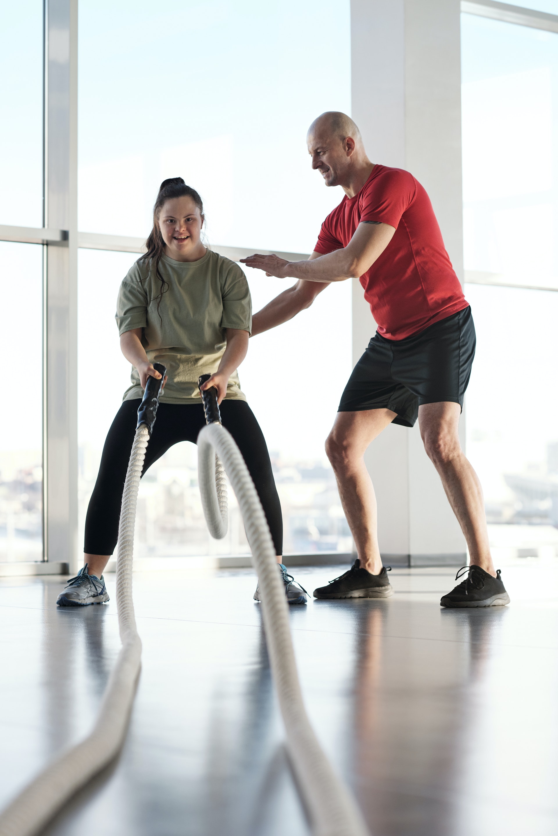 A trainer helping a student with rope waves