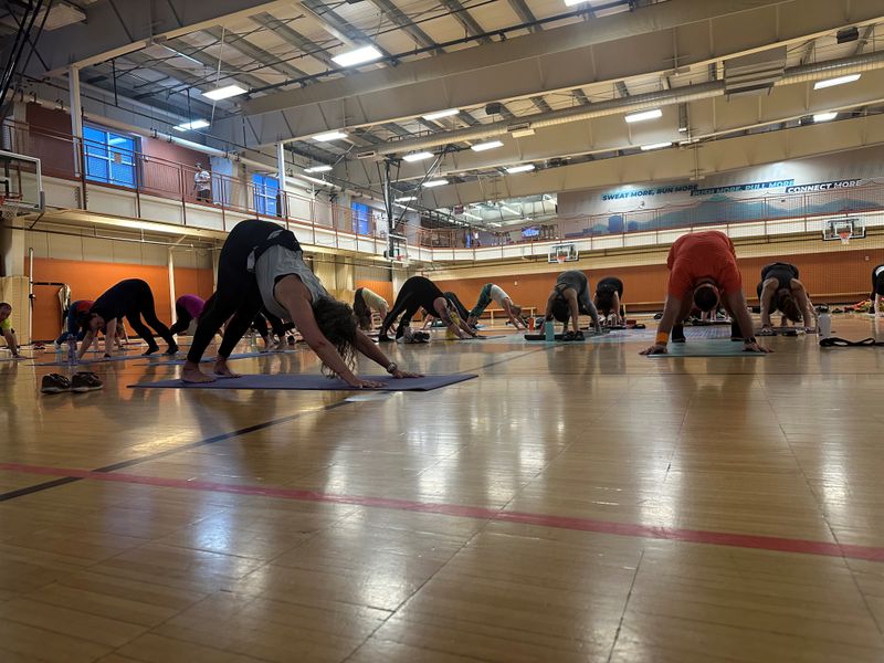 Members stretching together during a group fitness class on the court.